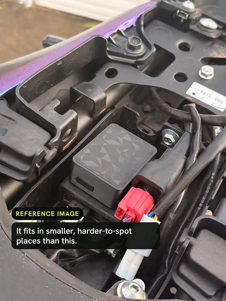 Sentrix under a motorbike seat, tucked in beside the wiring. Reference image: it fits in smaller, harder-to-spot places than this.